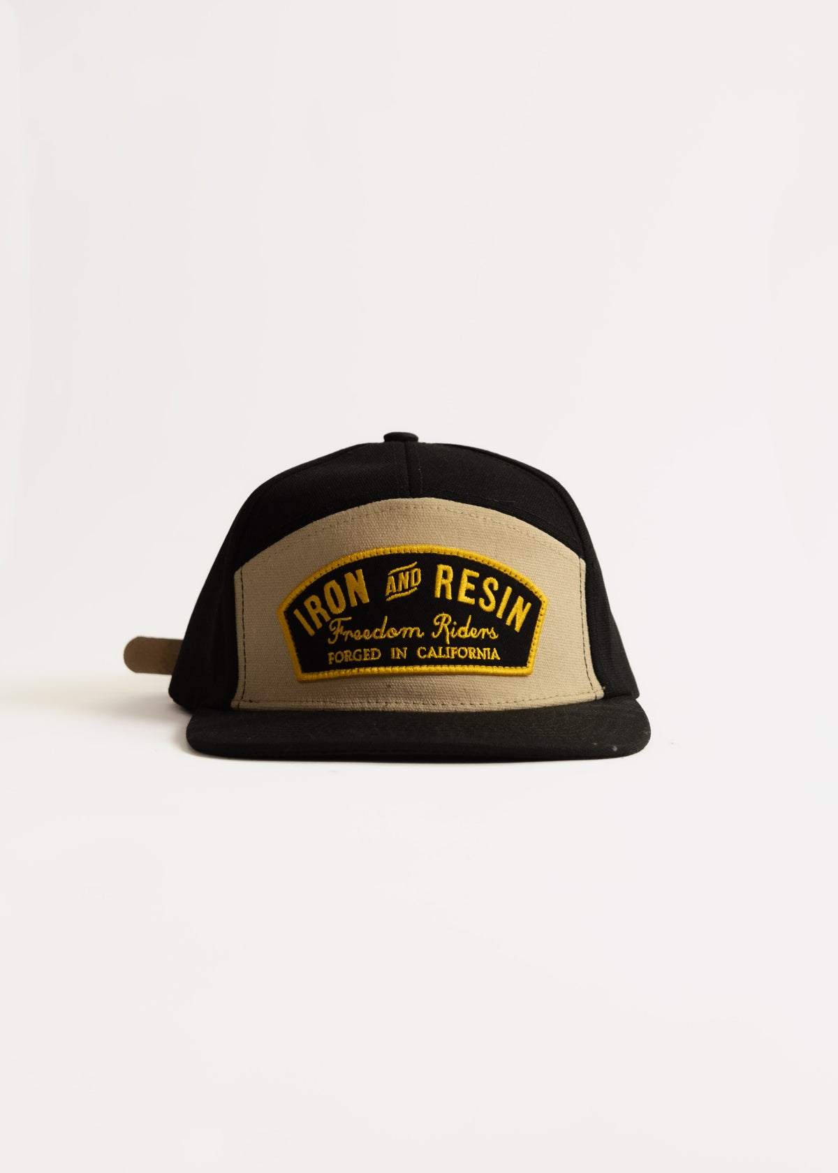 Black and beige cap with "Iron and Resin, Freedom Riders, Forged in California" text on front, isolated on white background.