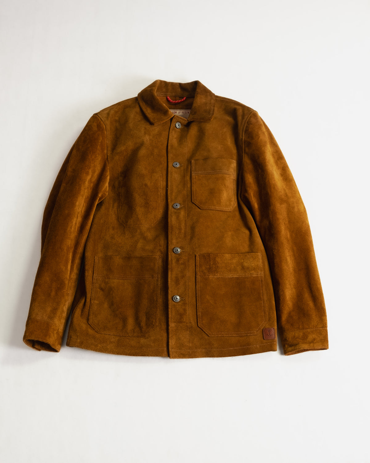 Brown suede jacket with button front, chest pocket, and two lower pockets on a white background, showcasing classic style.