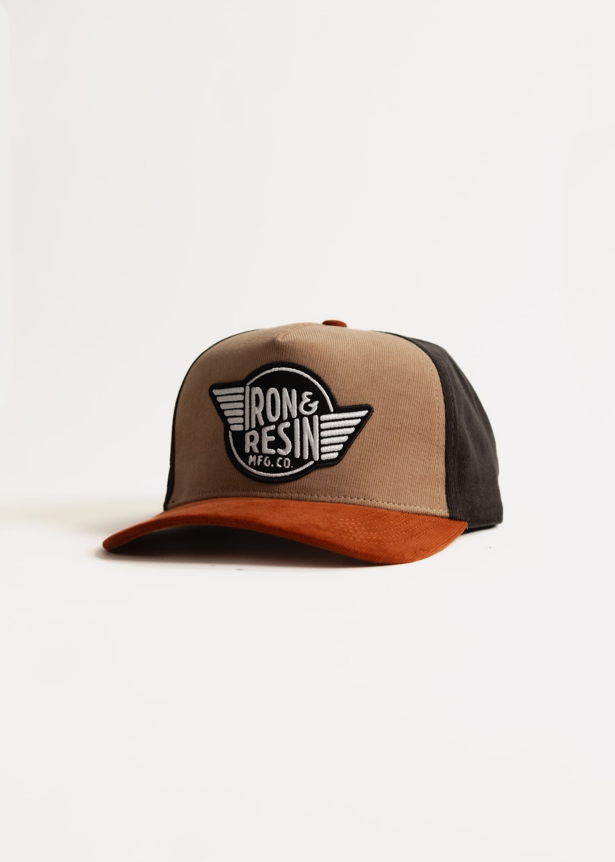 Brown and black cap with "Iron & Resin Mfg. Co." logo on front, featuring a rust-colored brim, isolated on a white background.